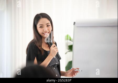 Businesswoman talking microphone present  business plan in meeting room Stock Photo