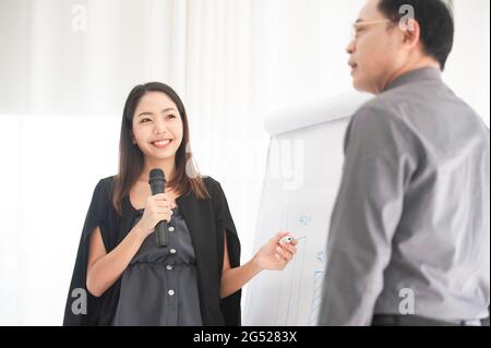Businesswoman talking microphone present  business plan in meeting room Stock Photo