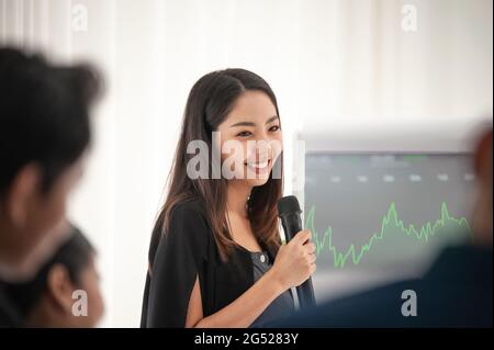 Businesswoman talking microphone present  business plan in meeting room Stock Photo