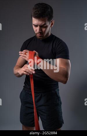 Young man wrapping hands with boxing tape Stock Photo