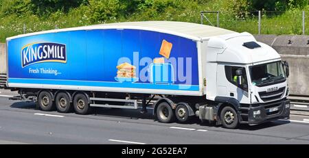 Advertising on articulated trailer for Kingsmill bread a brand owned by Associated British Foods behind an Iveco lorry truck driving on UK motorway Stock Photo