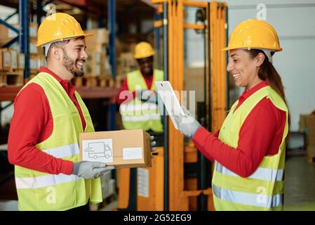 Cheerful warehouse workers with parcel and tablet Stock Photo