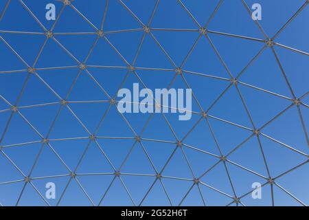 Steel polygon frame shell structure against blue sky Stock Photo
