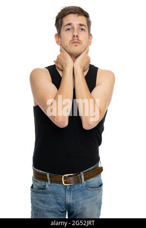 Young handsome tall slim white man with brown hair grabbing his neck in black undershirt isolated on white background Stock Photo