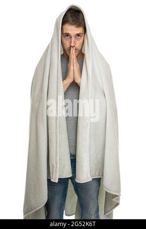 Young handsome tall slim white man with brown hair praying with blanket isolated on white background Stock Photo