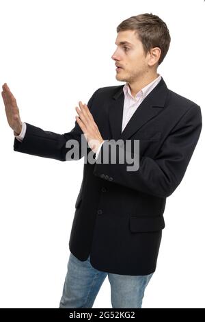 Young handsome tall slim white man with brown hair standing sideways in black blazer in blue jeans isolated on white background Stock Photo