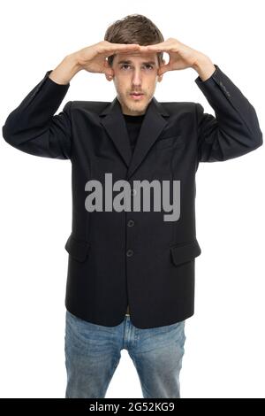 Young handsome tall slim white man with brown hair covers his eyes from sun in black blazer in blue jeans isolated on white background Stock Photo
