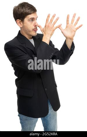 Young handsome tall slim white man with brown hair doing long nose with both hands in black blazer isolated on white background Stock Photo