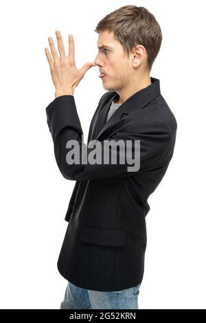 Young handsome tall slim white man with brown hair doing long nose in black blazer in blue jeans isolated on white background Stock Photo