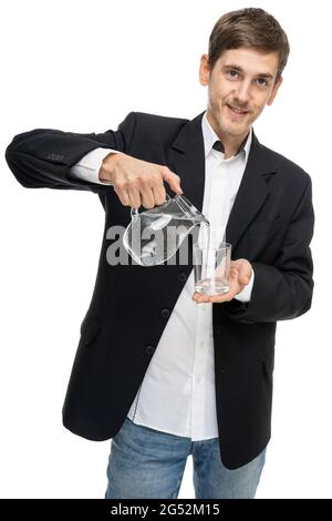 Young handsome tall slim white man with brown hair pouring water from a glass pitcher in black blazer isolated on white background Stock Photo