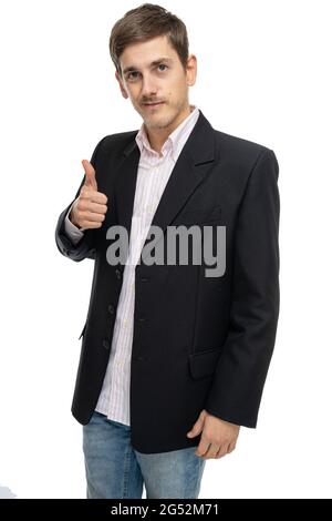 Young handsome tall slim white man with brown hair giving thumb up in black blazer isolated on white background Stock Photo