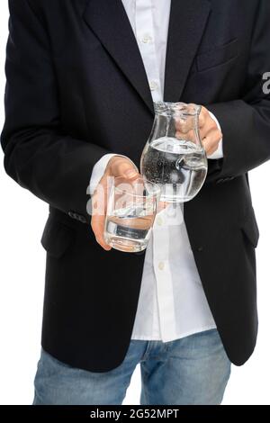 Young tall slim white man with glass pitcher of water and glass of water in close up in black blazer isolated on white background Stock Photo