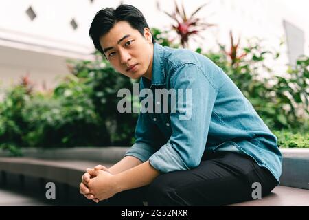 Asian handsome young man in green garden background Stock Photo