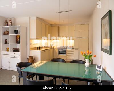 Modern house open plan kitchen diner dining room with dining table, Netherlands Stock Photo