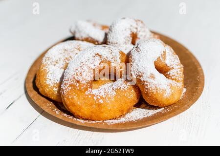 Dessert crumpet with powdered sugar on a cardboard plate on a wooden table. Stock Photo