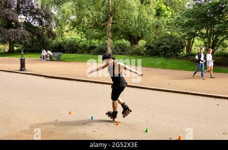 LONDON HYDE PARK LONDON'S CULTURAL DIVERSITY EXPERT LONE ROLLER SKATER IN THE SERPENTINE ROAD Stock Photo