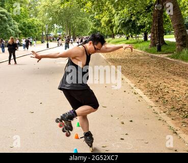 LONDON HYDE PARK LONDON'S CULTURAL DIVERSITY LONE ROLLER SKATER IN THE SERPENTINE ROAD Stock Photo