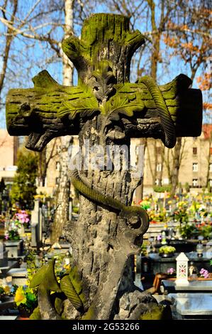 A cross on a grave in a Catholic cemetery by day. Summer. Stock Photo