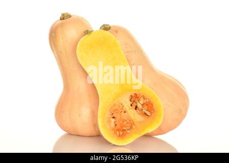 Two whole and one halves of ripe light yellow pumpkin, close-up, on a white background. Stock Photo
