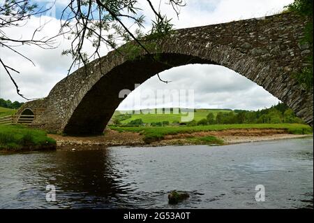 A view of an old stone arch bridge over the Gala water in the borders village of Stow in Scotland. Stock Photo
