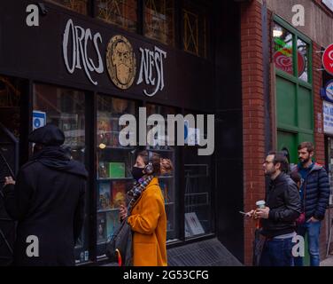 RPG Gaming Concept / Tech Lifestyle - View of several people queuing outside Orcs Nest game store, London, Britain 2020 Stock Photo
