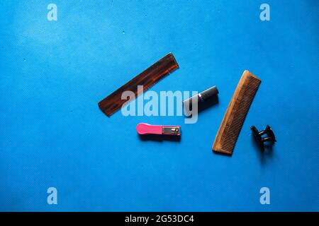 Grooming accessory items nail clipper, comb, hair clip and lipstick on a background with use of selective focus Stock Photo