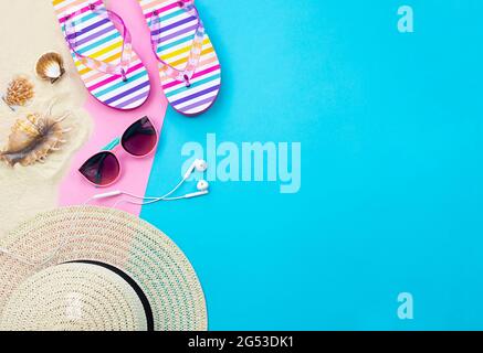 Trendy summer background with empty space for text. Summer leisure items are laid out on a blue and pink background. Summer hat, sunglasses Stock Photo