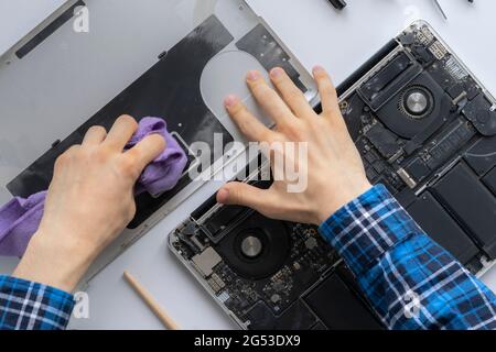 man's hands working in computer service and remove dust from the personal laptop Stock Photo