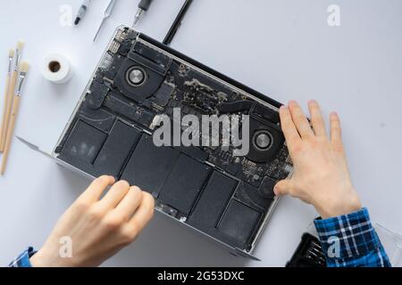 man's hands working in computer service and remove dust from the personal laptop Stock Photo