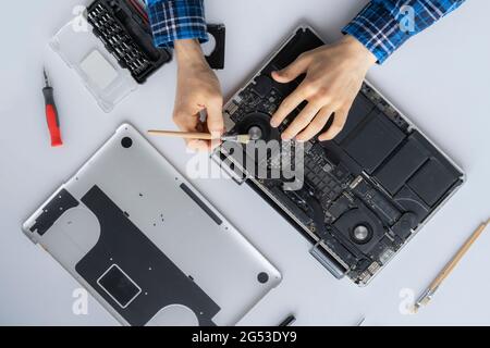 man's hands working in computer service and remove dust from the personal laptop Stock Photo