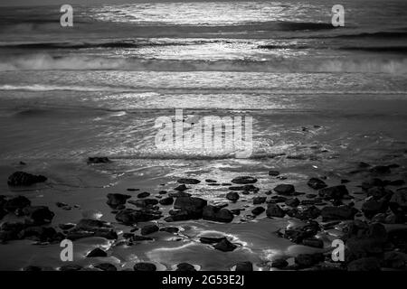 Beautiful seascape with a reflection of moon lights by night in black and white Stock Photo