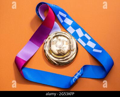April 25, 2021 Tokyo, Japan. Gold medal of the XXXII Summer Olympic Games in Tokyo on a yellow background. Stock Photo