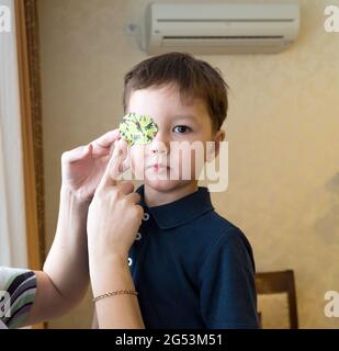 Little boy with okluder on the eye. Stock Photo