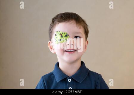 Little boy with okluder on the eye. Stock Photo