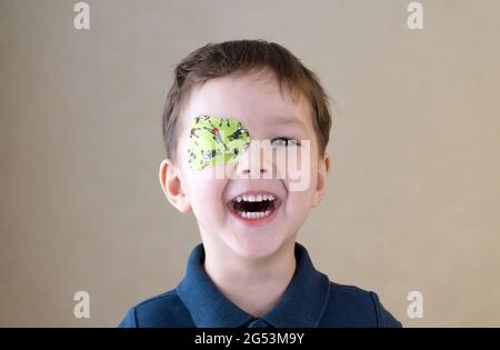 Little boy with okluder on the eye. Stock Photo