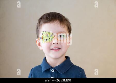 Little boy with okluder on the eye. Stock Photo