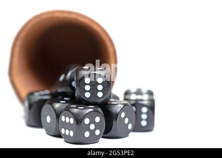 Black dice and dice cups against a white background Stock Photo