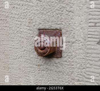 large rusty red metal nut on old 19th century wall Stock Photo