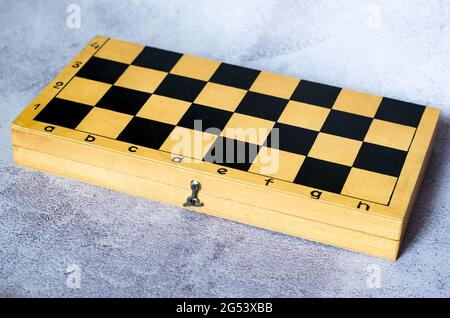 Closed wooden chess board on a gray background. Stock Photo