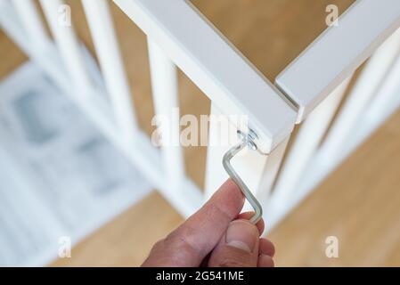 close-up of person assembling furniture using a hex wrench Stock Photo