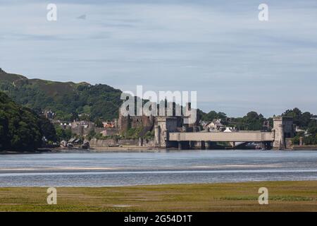 Looking across the River Conwy at Conwy Castle with the metal train line tunnel visible in the scene. Stock Photo