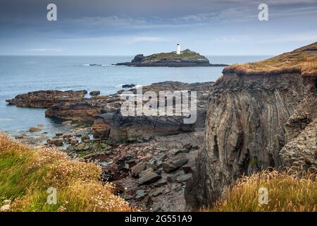 The rugged cornish coastline at Godrevy Head viewed from Godrevy Point, with Godrevy Lighthouse in the distance. Stock Photo