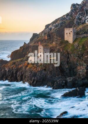 The ruins of the Crowns Engine Houses perched on the granite cliffs at Botallack in Cornwall. Taken at sunset. Stock Photo