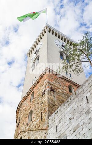 Ljubljana, Slovenia - August 15, 2018: The Panoramic Tower of the Ljubljana Castle and its flag under a cloudy sky Stock Photo