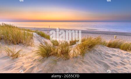 Sunset View over ocean from dune over North Sea and Canal in Ouddorp, Zeeland Province, the Netherlands. Outdoor scene of coast in nature of Europe. Stock Photo