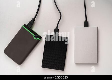 three external hdd drives one the shelf, data backup storage Stock Photo
