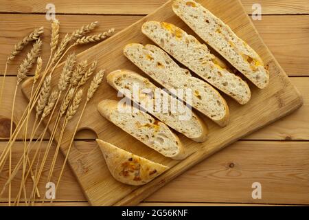 Fresh whole grain bread with cheese and ham. Natural food concept. Loaf of organic bread on wooden background. Stock Photo