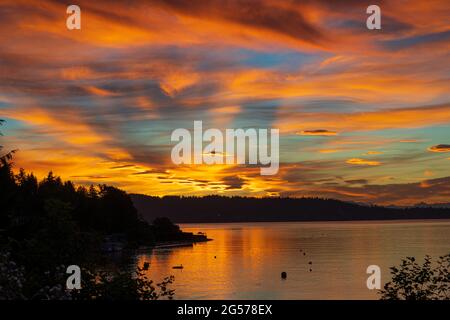 Shadows of the Cascade mountain range reflect on the sun streaked skies pre-sunrise Stock Photo