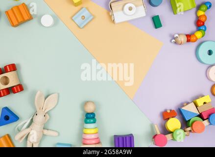 Wooden baby cubes on violet-green beige background. Educational toys blocks, pyramids, car. Toys for kindergarten, preschool or daycare. Stock Photo