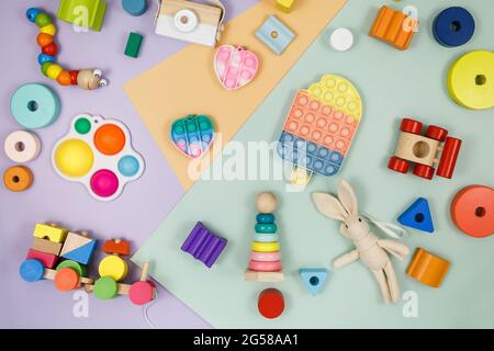 Wooden baby cubes on violet-green beige background. Educational toys blocks, pyramids, car. Toys for kindergarten, preschool or daycare. Stock Photo